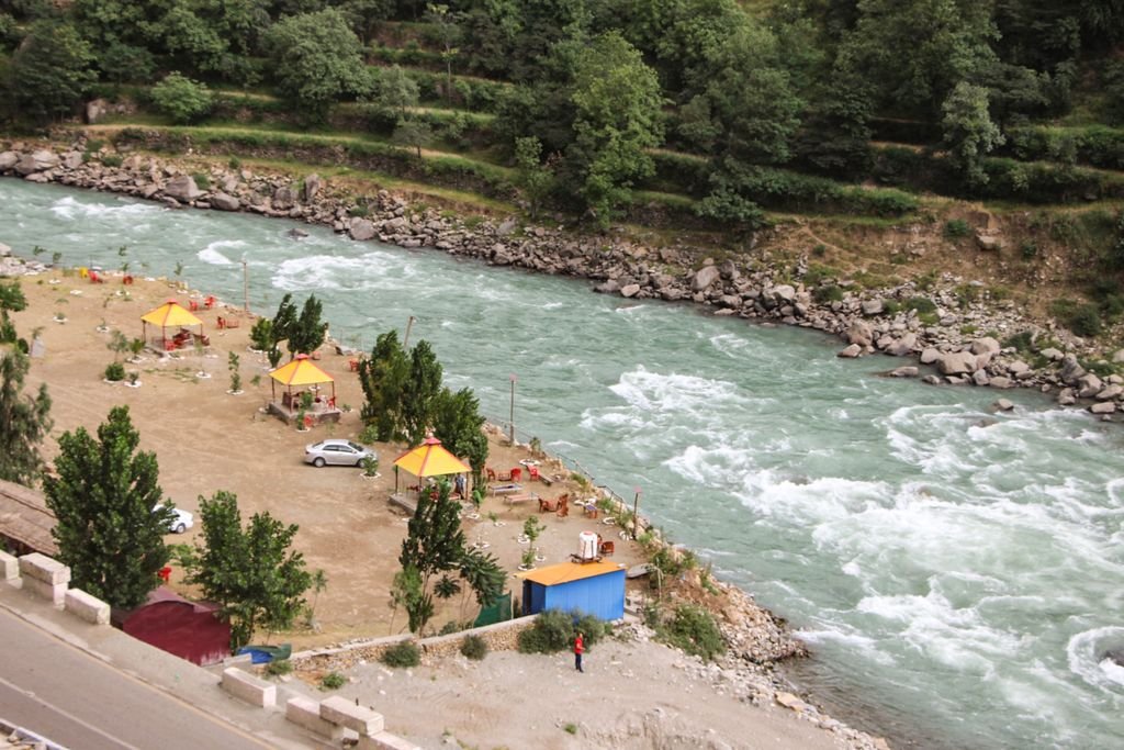 Picturesque huts along Swat River in Madyan, ideal for nature tourism.