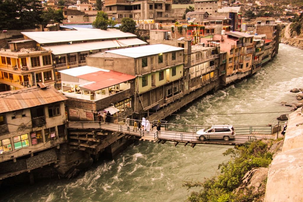 Picturesque view of a bridge over the Swat River in Bahrain, Khyber Pakhtunkhwa, Pakistan, capturing daily life.