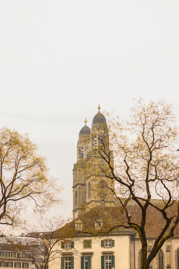 View of Grossmünster Cathedral through autumn trees in Zurich, Switzerland.